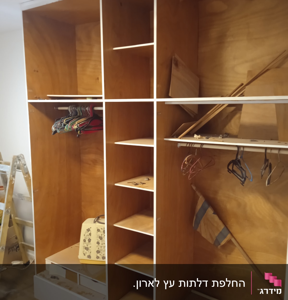 ארון עץ בבנייה עם מדפים וקולבים